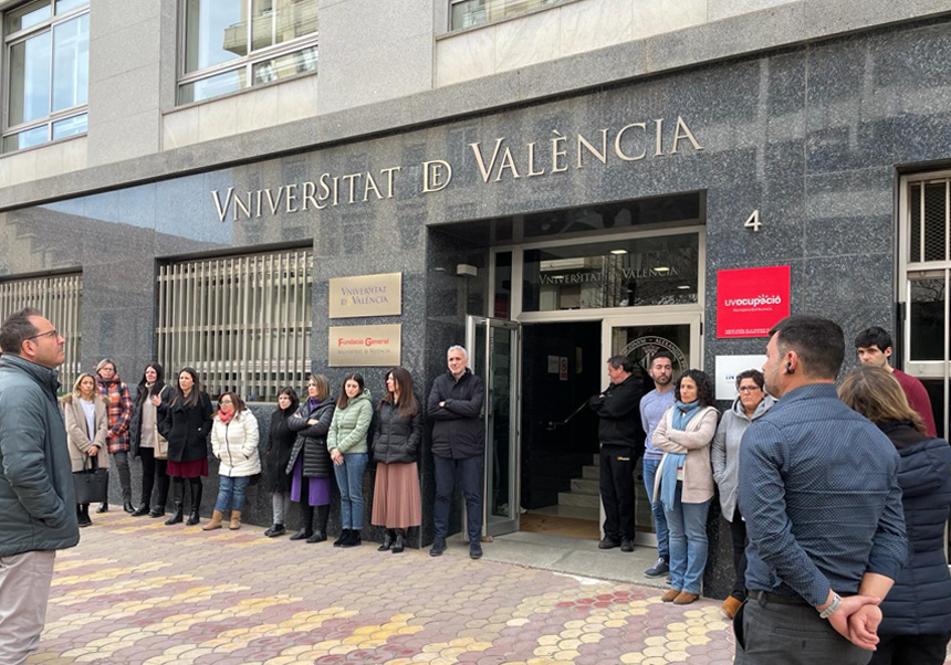 Personal de Fundació i UV a la porta de l'entitat guardant un minut de silenci